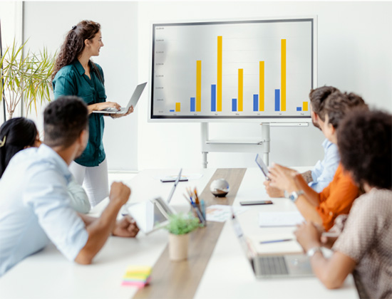 Woman giving presentation in front of team.